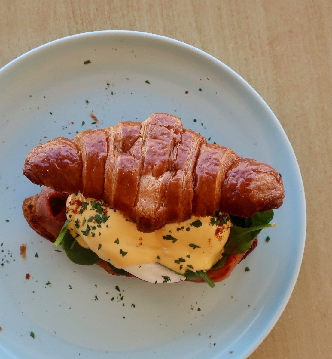Croissant sandwich with egg, bacon and spinach