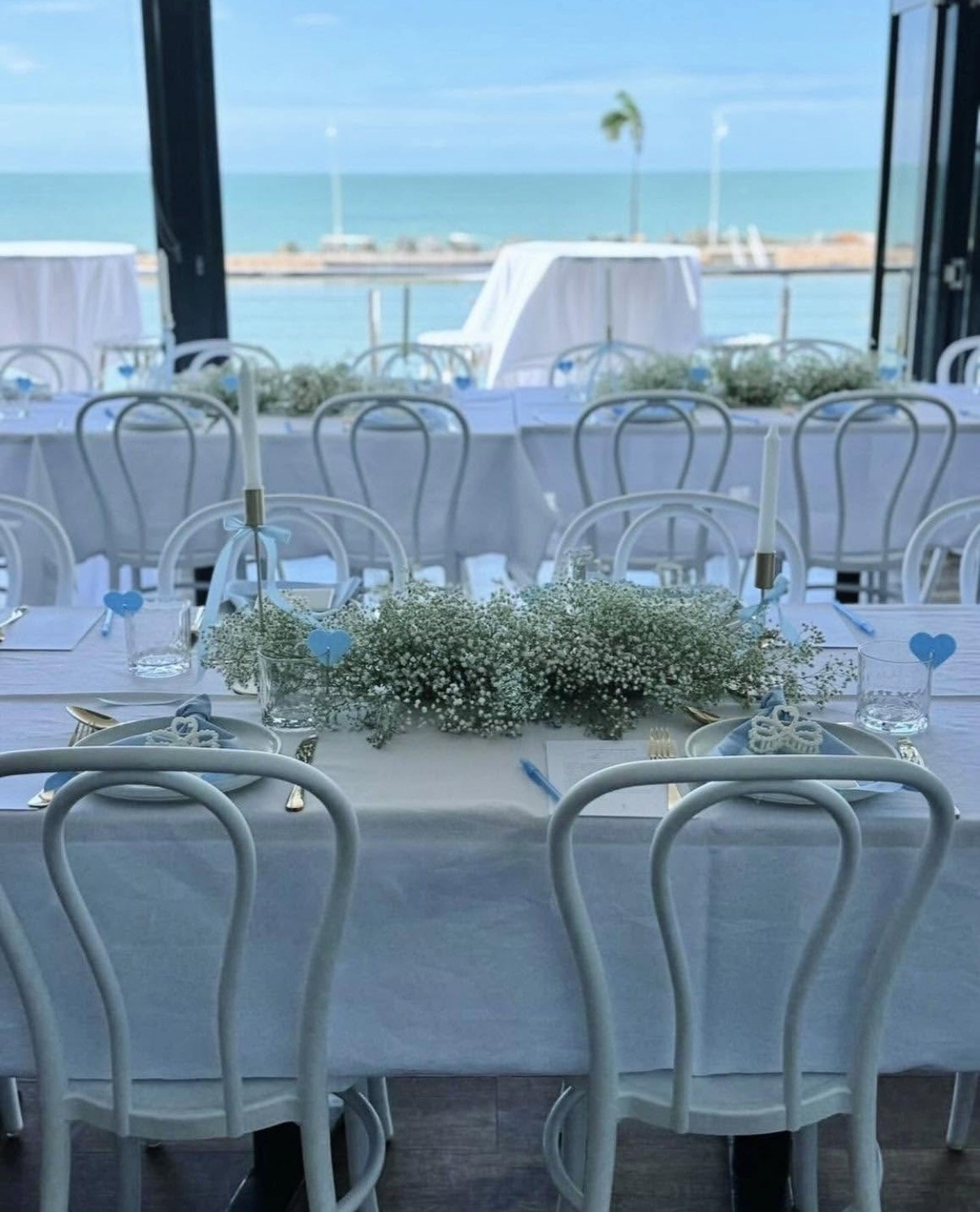 Blue-themed event setup with gypsophila and ocean views